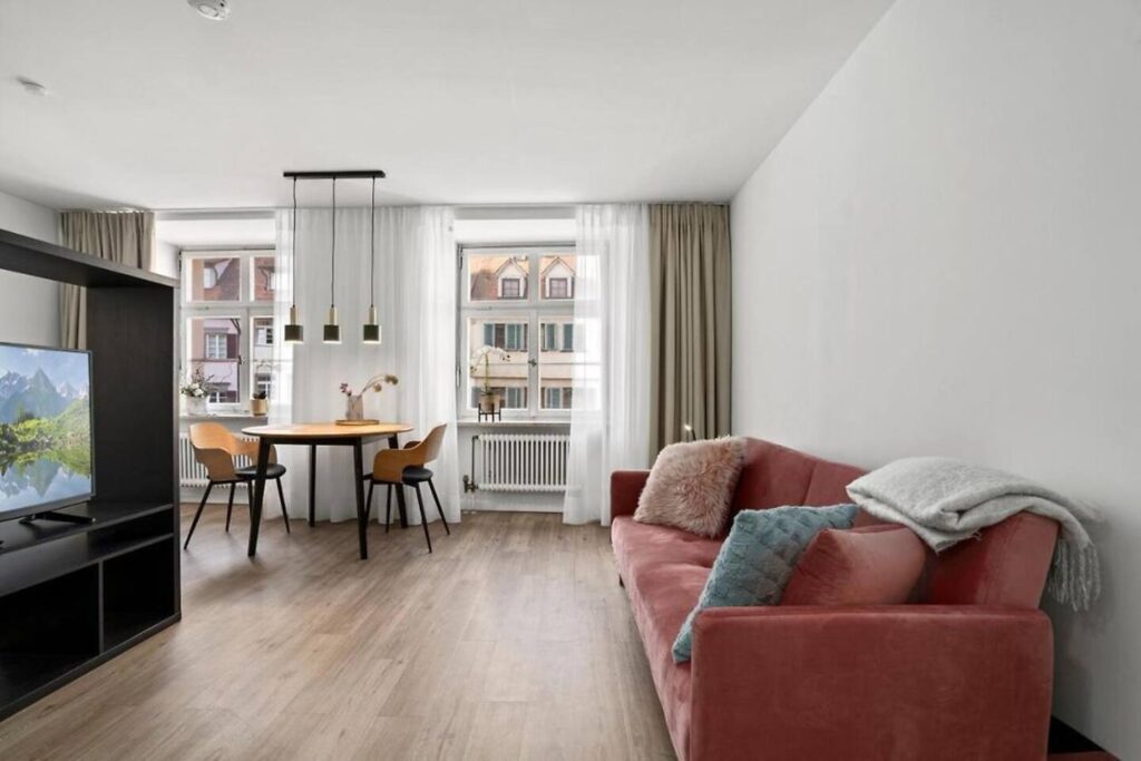 1-Zimmer-Wohnung mit rotem Sofa und Esstisch