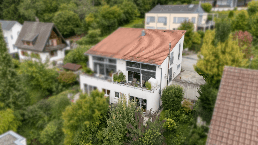 Bild von einem Doppelhaus mit viel grün drum herum.