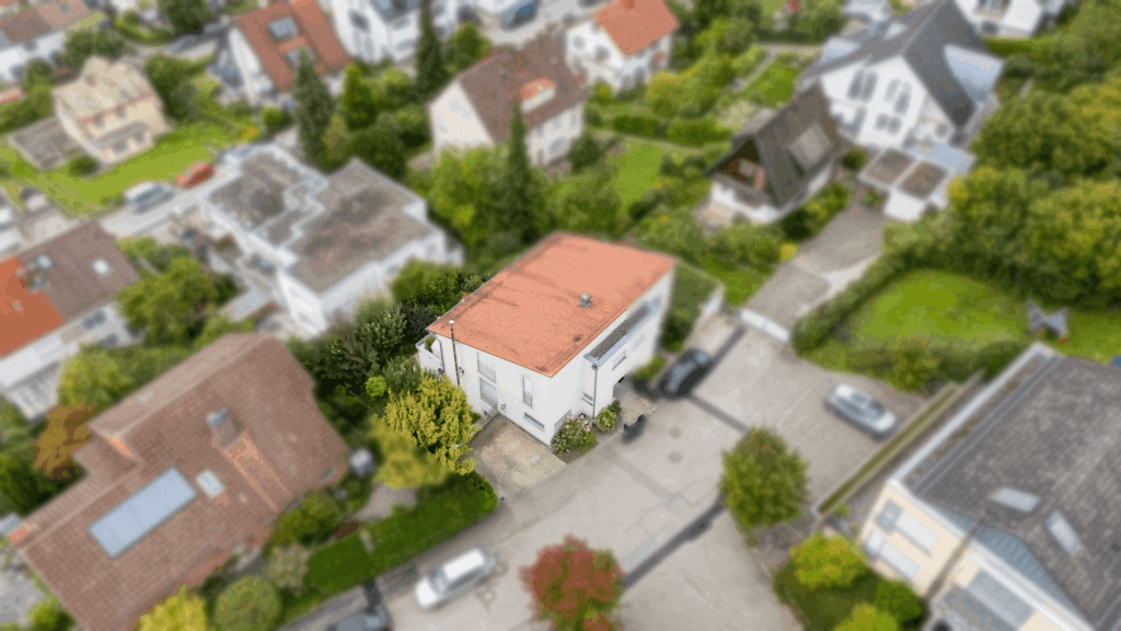 Bild von einem Doppelhaus mit viel grün drum herum.