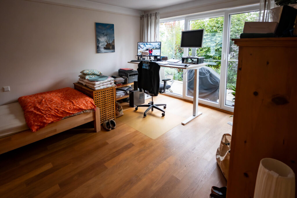 Zimmer mit Schreibtisch und großem Fenster